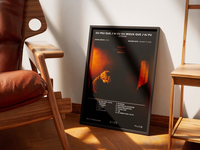 May include: A framed poster with the text "DU PEU QUE J'AI EU DU MIEUX QUE J'AI PU" and "LESRAM" in white font. The poster has a dark background with orange and yellow hues. The album's tracklist is listed at the bottom.