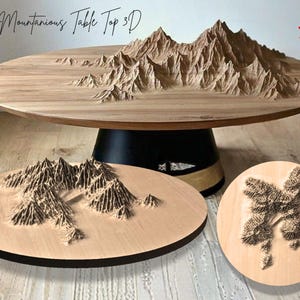 Peut inclure: Une table en bois avec un motif de chaîne de montagnes en 3D sur le plateau. La table a un socle sombre et est accompagnée de deux petites pièces en bois assorties avec des motifs de montagnes et d'arbres. Le texte "Mountainous Table Top 3D" est visible.