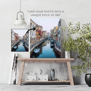Op de afbeelding: Een schilderij van een kanaal in Veneti&euml;, Itali&euml;. Het kanaal wordt geflankeerd door kleurrijke gebouwen en boten drijven op het water. Het schilderij is in een schilderachtige stijl met zichtbare penseelstreken.