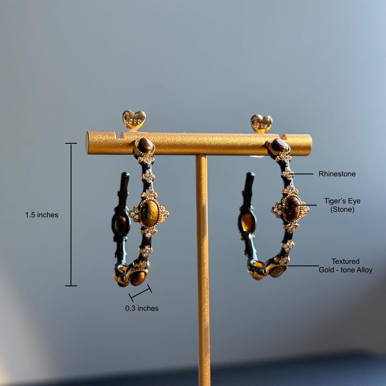 Textured gold tone hoop earrings with tiger’s eye stones and rhinestones, labeled dimensions 1.5 x 0.3 inches showing detailed craftsmanship