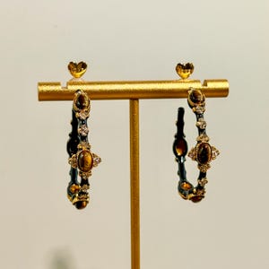 Close-up of textured gold bamboo hoop earrings featuring tiger’s eye stones and sparkling rhinestones, elegant handmade detailing