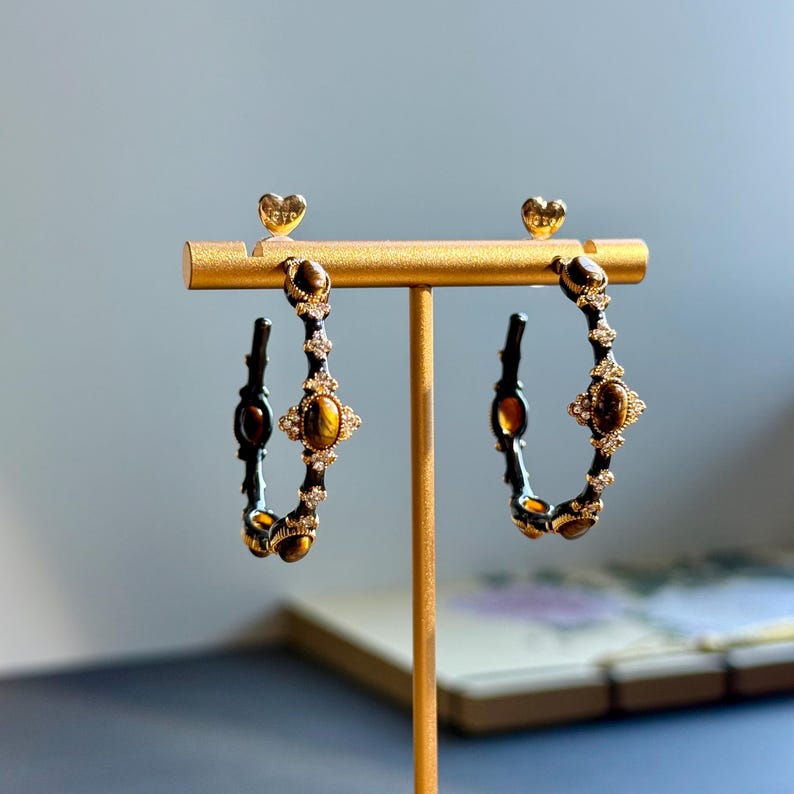 Close-up of textured gold bamboo hoop earrings featuring tiger’s eye stones and sparkling rhinestones, elegant handmade detailing