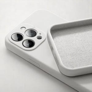 May include: A white phone case with a soft, textured interior. The case is designed to fit a smartphone, with cutouts for the camera lenses and other features. The case is made of a durable material and offers protection against scratches and impacts.