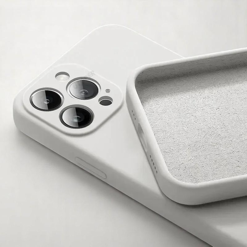 May include: A white phone case with a soft, textured interior. The case is designed to fit a smartphone, with cutouts for the camera lenses and other features. The case is made of a durable material and offers protection against scratches and impacts.