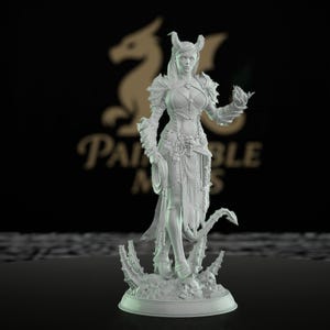 May include: A detailed, unpainted miniature figurine of a female fantasy character. She wears armor, has horns, and holds a whip and a glowing orb. The base features skulls and a textured surface. The background has a logo.
