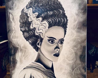 Peut inclure: Peinture de portrait en noir et blanc d'une femme au maquillage saisissant et à la coiffure distinctive. Les cheveux de la femme sont coiffés en chignon avec une mèche blanche. La peinture est sur un fond flou.