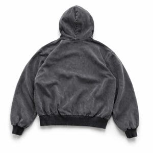 Puede incluir: Una sudadera con capucha gris carb&oacute;n con una apariencia descolorida y vintage. La vista trasera muestra una sudadera con capucha con cord&oacute;n, mangas largas y dobladillo y pu&ntilde;os acanalados. La tela tiene una textura suave y desgastada.