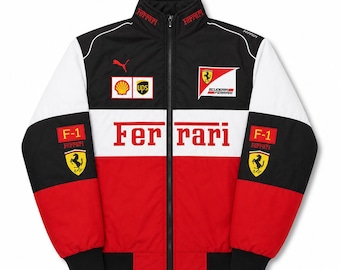 以下が含まれることがあります： フェラーリのロゴ、Ferrariの文字、Shell、UPS、F-1などのスポンサーパッチがあしらわれた、黒、白、赤のジップアップジャケット。襟にはFerrariの文字があり、黒い袖口の長袖で、Pumaのロゴが施されています。