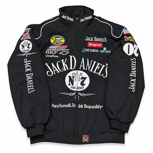 Op de afbeelding: Zwarte racejas met witte details en sponsorlogo's. De jas toont prominent het Jack Daniel's logo. Bevat de tekst "Pace Yourself. Drink Responsibly."
