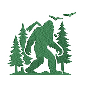 May include: A green embroidery design featuring a silhouette of a Bigfoot creature walking through a forest of pine trees. The scene includes two birds flying in the upper right corner and a small tree stump on the ground near the pine trees.