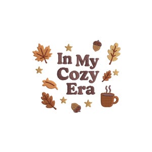 Op de afbeelding: Een geborduurd ontwerp met de tekst "In My Cozy Era" in bruin, omringd door herfstthema-elementen zoals bladeren, eikels, sterren en een koffiekopje, allemaal in warme herfstkleuren.