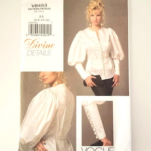 May include: Vogue pattern V8453 for a blouse with puff sleeves and button details. The pattern includes sizes AA (6-8-10-12). The image shows a woman wearing the blouse. The text "Divine Details" is visible.