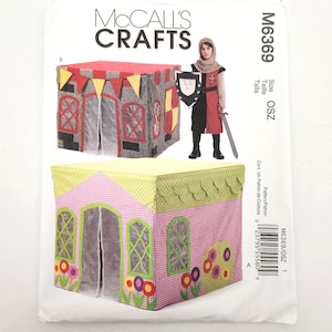 May include: McCall's Crafts pattern for a child's playhouse and knight costume. The playhouse designs include a gray castle with red and yellow accents and a pink house with floral details. The knight costume is red and black.