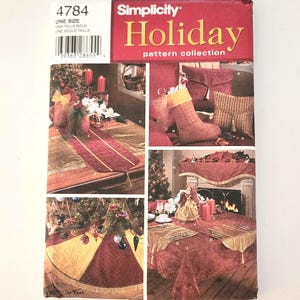 May include: A Simplicity Holiday pattern collection featuring various Christmas sewing projects. The cover displays images of a table runner, tree skirt, stocking, and tablecloth, all with a festive theme. The pattern number is 4784.