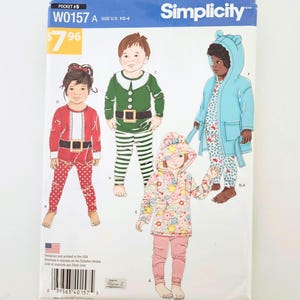 Könnte beinhalten: Simplicity-Schnittmuster W0157 A für Kinderkleidung, mit Illustrationen von Kindern in festlichen Outfits. Das Muster enthält einen Weihnachtsmann-Anzug, ein Elfenkostüm und einen Kapuzenmantel. Größe US 1/2-4.