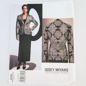May include: A pattern envelope featuring a woman wearing a black and gold patterned blazer and a black skirt. The blazer has a unique design, and the envelope includes the text "ISSEY MIYAKE VOGUE DESIGNER ORIGINAL". The pattern number is 2768.