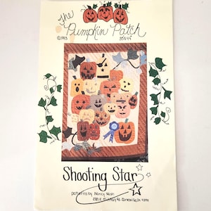 May include: A vintage quilt pattern titled "The Pumpkin Patch" featuring a patchwork design of various jack-o'-lantern faces. The pattern measures 35 x 44 inches and includes the text "Shooting Star" and the designer's name and address.