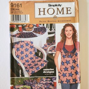 Puede incluir: Patr&oacute;n de accesorios para anfitriones de picnic Simplicity Home. El patr&oacute;n presenta a una mujer que lleva un delantal con un dise&ntilde;o de estrellas rojas, blancas y azules. La imagen muestra cojines para sillas, un mantel y otros art&iacute;culos de picnic.