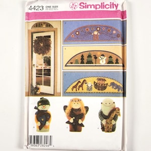 Puede incluir: Un sobre de patrón de costura Simplicity 4423 con instrucciones para adornos de puerta de tela y tres muñecos de peluche. Los diseños incluyen un muñeco de nieve, un ángel y una figura barbuda que sostiene una jirafa, con varios motivos.