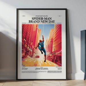 May include: A framed movie poster titled Spider-Man Brand New Day featuring a central illustration of Spider-Man swinging between tall city buildings in a vibrant red and orange color palette with cast names and production details printed below.
