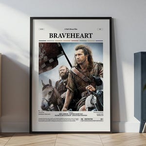 May include: A framed movie poster for the film Braveheart, featuring a central image of a man with long hair on horseback alongside another person. The poster includes the title Braveheart in bold black text, cast names, and a restricted rating icon.