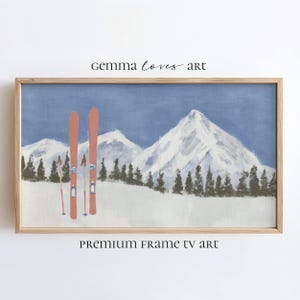 Pode incluir: Pintura emoldurada de uma paisagem de montanha nevada com esquis e bastões. A obra apresenta um céu azul, neve branca e árvores verdes. Os textos "Gemma Loves Art" e "Premium Frame TV Art" são visíveis.