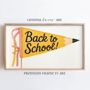 Pode incluir: Impressão emoldurada com uma flâmula amarela em forma de lápis com a inscrição "Back to School!" em preto. A flâmula tem uma fita rosa e está sobre um fundo branco. A moldura é de cor castanho claro.