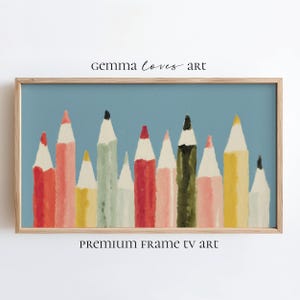 May include: A framed art print featuring a collection of colorful pencils against a light blue background. The pencils are in shades of red, pink, yellow, and green, with white tips and black accents. The text "Gemma Loves Art" and "Premium Frame TV Art" are visible.