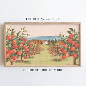 May include: A framed print of an apple orchard in autumn. Rows of apple trees laden with red fruit lead to a white house and distant mountains. The artwork is labeled "Gemma Loves Art" and "Premium Frame TV Art".