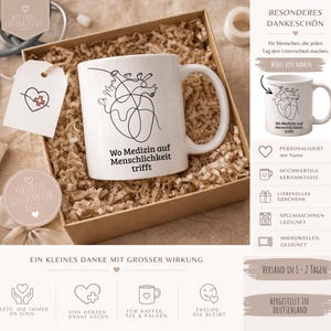 May include: White ceramic mug with a black line drawing of a heart and the text "Wo Medizin auf Menschlichkeit trifft". The mug is in a gift box with a tag that says "Perfektes Geschenk f&uuml;r &Auml;rzte".