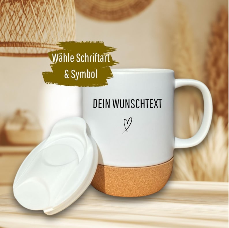 May include: White ceramic mug with a cork base and a white lid. The mug has the text "DEIN WUNSCHTEXT" and a heart symbol. The text "W&auml;hle Schriftart & Symbol" is also visible.