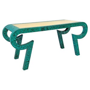 May include: A console table featuring a vibrant teal and black marbled pattern across its frame. The table has a long, rectangular top with a smooth, light cream-colored surface and four curved, angular legs that extend outward from the sides.