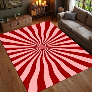 Puede incluir: Alfombra de rayas rojas y rosas con un patrón de rayos de sol. La alfombra tiene un diseño circular con rayas que irradian hacia afuera desde el centro.