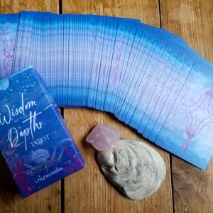 Wisdom of the Depths tarot deck - a view of the tuck box and the back of the cards.  There's an oyster shell and a piece of rose quartz for decoration.