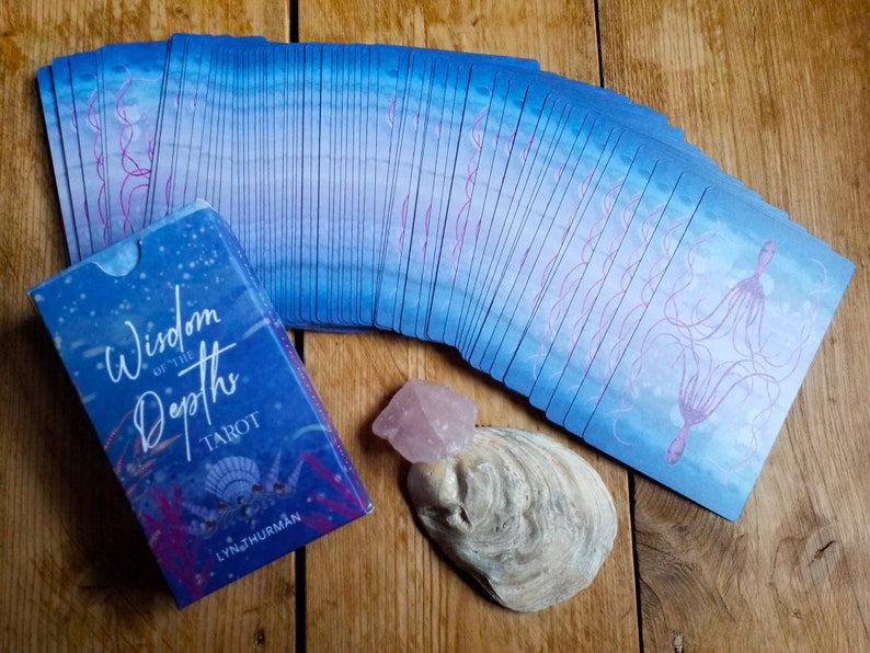 Wisdom of the Depths tarot deck - a view of the tuck box and the back of the cards.  There's an oyster shell and a piece of rose quartz for decoration.