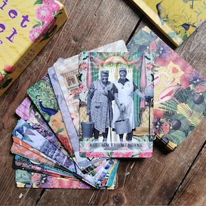 May include: A deck of colorful oracle cards with a card showing two women in vintage clothing holding buckets. The card reads "Reclaim the Mundane Mindfulness".