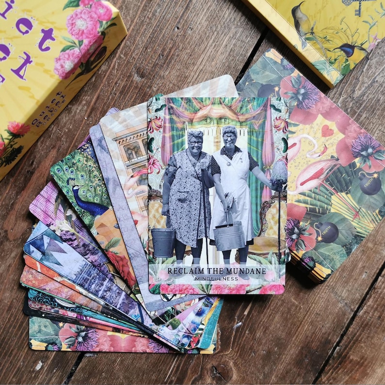 May include: A deck of colorful oracle cards with a card showing two women in vintage clothing holding buckets. The card reads "Reclaim the Mundane Mindfulness".