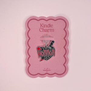Op de afbeelding: Een roze "Kindle Charm" tag met een horror-thema bedel. De bedel heeft een zwart mes, een rood hart met bloedspetters en het woord "HORROR" in rode letters.
