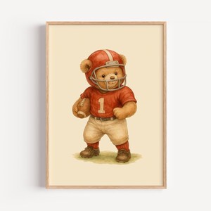 Pu&ograve; includere: Un orsacchiotto di peluche marrone che indossa una divisa da football rosso e bianco con un casco e tiene un pallone da football. L'orso &egrave; in piedi su uno sfondo beige.