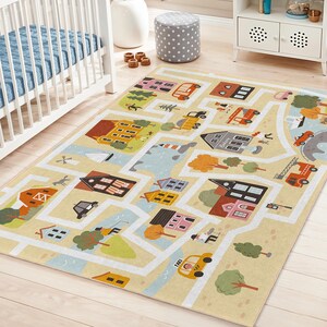 May include: A rectangular children's rug with a town map design. The rug features roads, buildings, trees, and vehicles in various colors, including yellow, blue, red, and green. The rug is placed on a light-colored wooden floor.