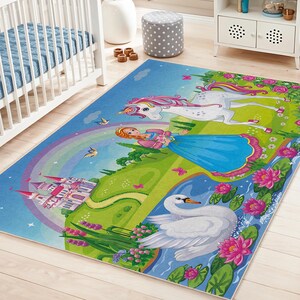 Può includere: Un colorato tappeto per bambini con una principessa, un unicorno, un cigno e un castello. Il tappeto ha uno sfondo blu con un arcobaleno, colline verdi e fiori rosa. Adatto per una cameretta o una sala giochi.