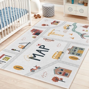May include: A rectangular, light gray children's play rug with a city map design. The rug features roads, buildings, vehicles, and the word "MAP" in large black letters. The design includes a school bus, crane, and trees.