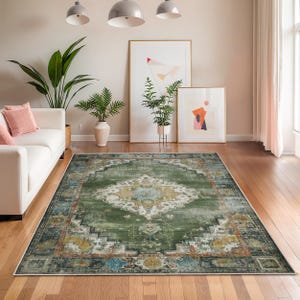 May include: A large, rectangular area rug with a distressed, vintage look. The rug features a central medallion design in shades of green, blue, and cream, with a border in darker tones. The rug is placed on a hardwood floor in a living room setting.