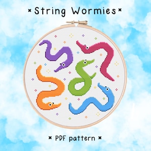 Puede incluir: Patrón de punto de cruz con cinco criaturas coloridas con forma de gusano sobre un fondo blanco. El patrón se titula "String Wormies" e incluye el texto "PDF pattern".