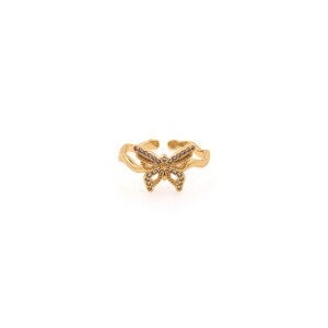 May include: A gold-toned ring with a butterfly design. The butterfly is adorned with small, clear stones.