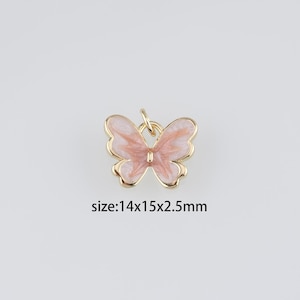 Könnte beinhalten: Goldfarbener Schmetterlingsanhänger mit rosa Emaille. Der Schmetterling misst 14x15x2,5 mm.