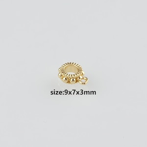 Könnte beinhalten: Ein kleines, goldfarbenes Schmuckteil mit Ringform und kleiner Schlaufe. Das Teil ist mit kleinen, runden Perlen am äußeren Rand verziert. Der Text "size: 9x7x3mm" ist darunter gedruckt.