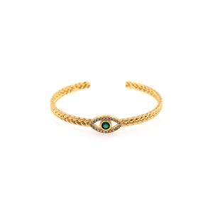 May include: A gold bracelet with a braided design and an evil eye charm with a green stone and clear rhinestones.