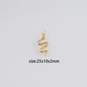 Könnte beinhalten: Goldfarbener Schlangen-Anhänger, misst 2,5 cm x 1 cm x 0,2 cm.