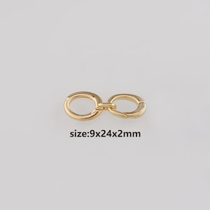 Puede incluir: Un cierre dorado con diseño de símbolo de infinito. El cierre metálico tiene un acabado brillante. El texto "size: 9x24x2mm" está impreso debajo. Medidas: 9mm x 24mm x 2mm.